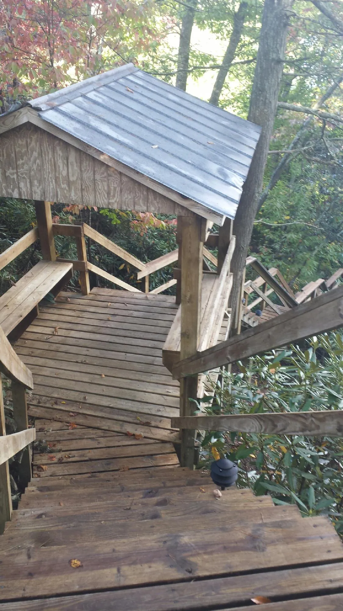 Metal roofed shelter over wooden steps on a wooded walkway — Skylight Repair & Installation work by our crew in Smithfield